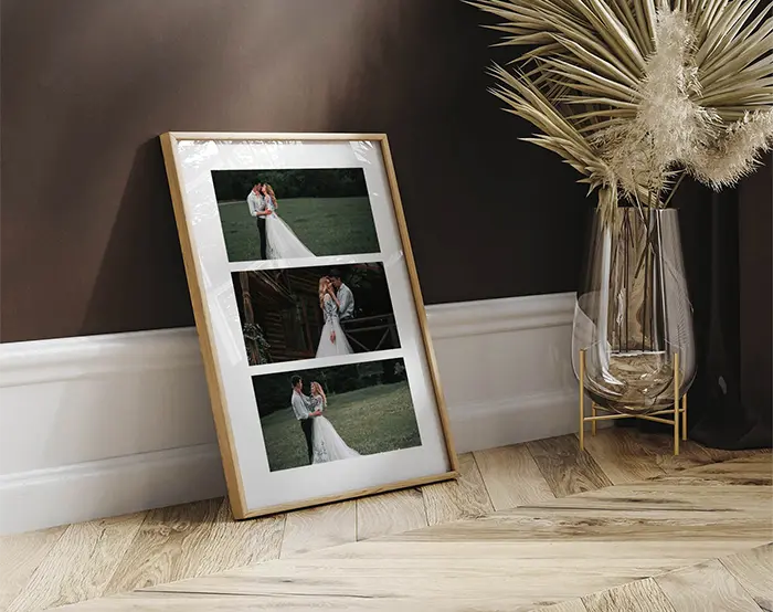 Framed wedding photo collage with three portraits leaning against dark feature wall