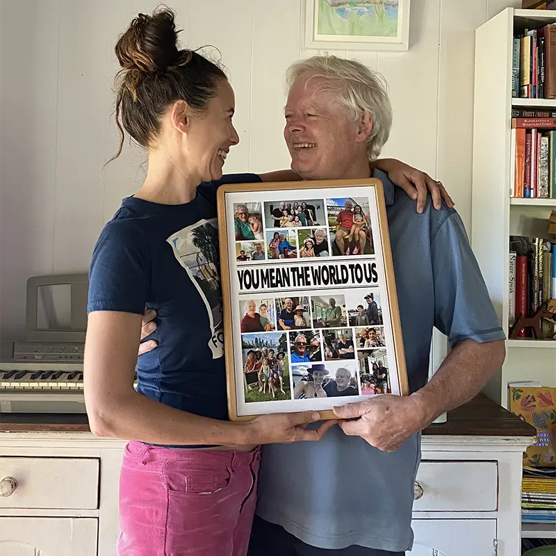 Father and daughter smiling while holding custom photo collage gift at home