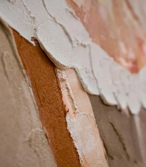 Close up texture detail of abstract wall art showing layered paint strokes