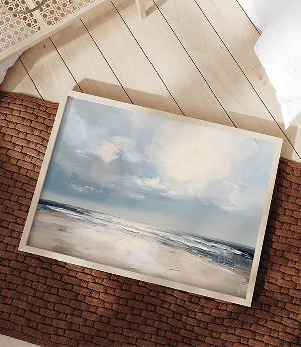 Coastal beach wall art with soft sky tones placed on timber floor near brick wall