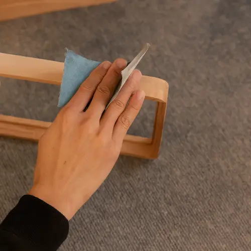 Hand sanding wooden photo frame edge to achieve smooth handcrafted finish