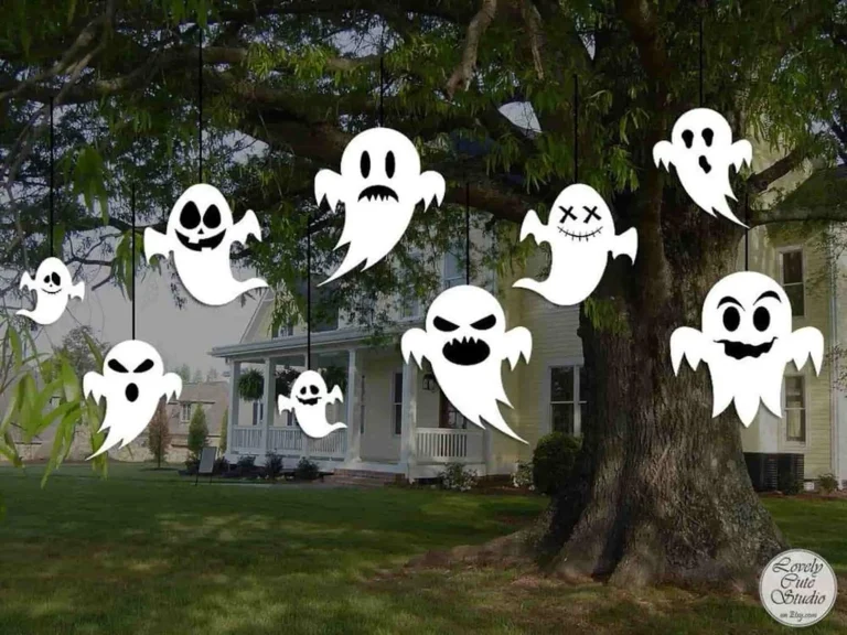 Hanging ghost decorations on tree branches creating spooky Halloween atmosphere