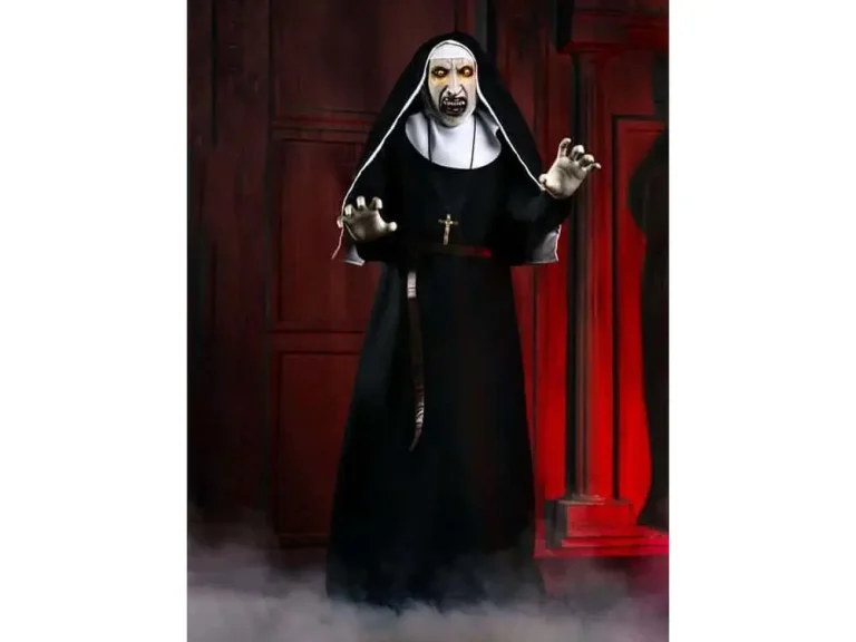 Scary nun halloween prop with glowing eyes standing in dark room with red light.