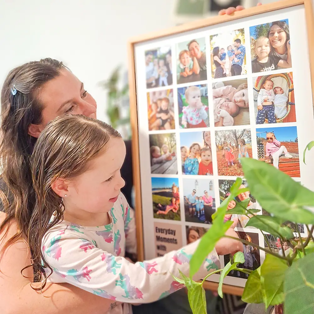 Mother and daughter looking at a custom photo collage wall art in a bright living room