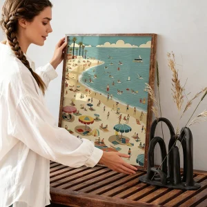 Person placing a framed coastal illustration on a wooden console