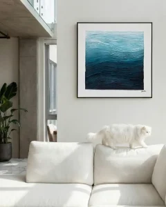 A contemporary living room featuring a blue gradient textured painting from Veeart above a white sofa.