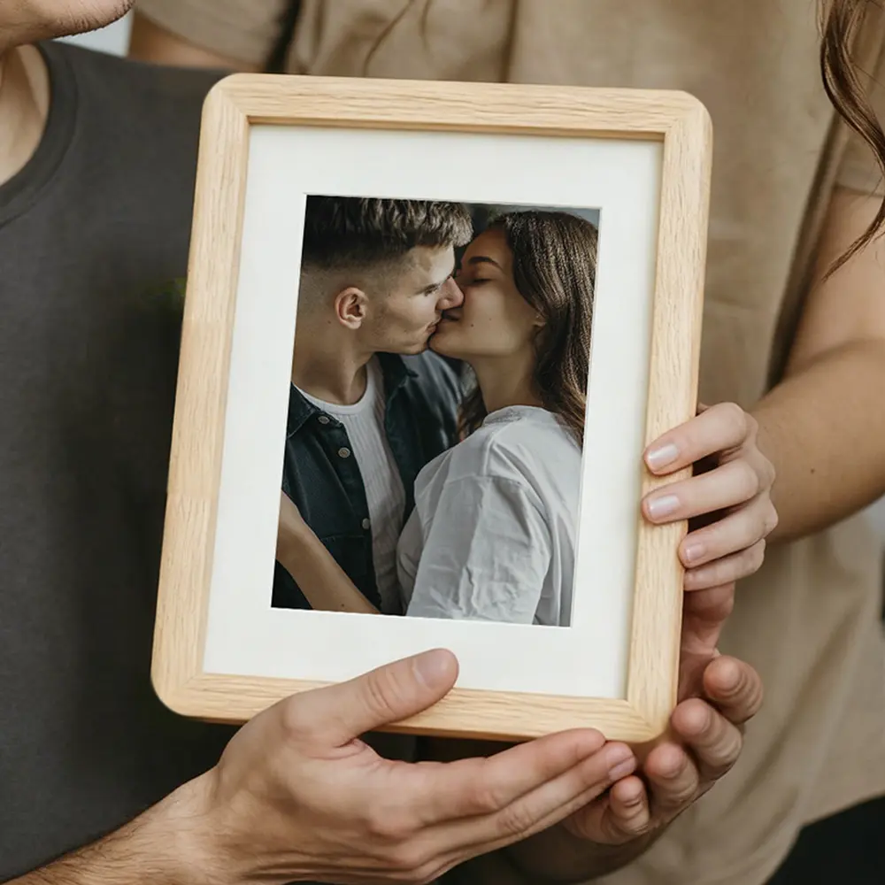 Couple holding a framed photo while standing together