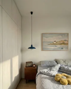 Coastal canvas wall art in a bright minimalist bedroom.