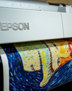 Close-up of a professional EPSON art printer producing a vibrant, high-resolution fine art print using archival pigment inks.