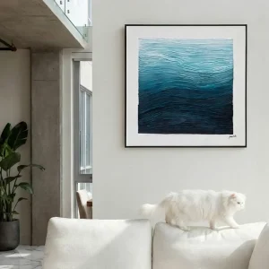 Ocean Depths textile art above a white sofa in a modern lounge