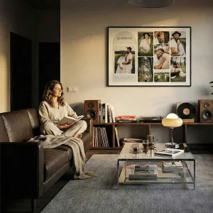 Cozy living room scene with a woman admiring a large custom framed photo collage wall art hanging above a credenza.
