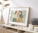 Minimalist family portrait illustration as custom wall art in a natural oak frame on a wooden sideboard.