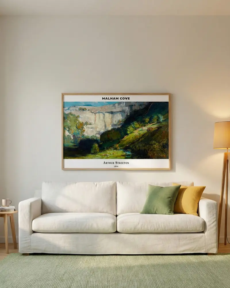 Horizontal landscape art by Arthur Streeton hanging 15-20cm above a light beige sofa in a cozy living room.