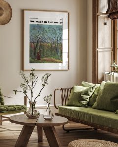 Vintage style art in wooden frame in boho living room with rattan furniture and plants.
